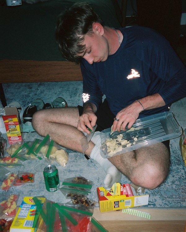 Crew member preparing single-portion snack bags before a backyard ultra