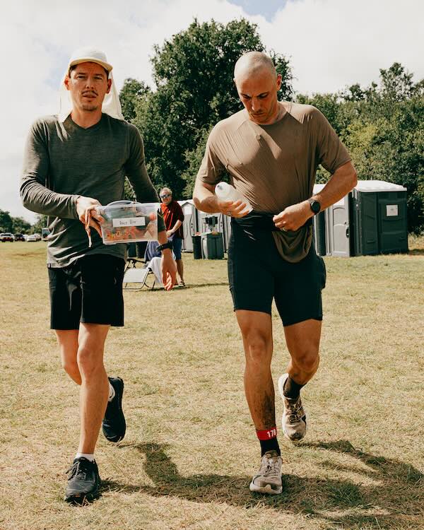 Crew member carrying a race box with everything the runner needs for the loop